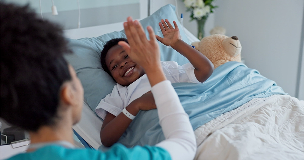 Krankenschwester gibt einem Kind im Krankenhaus ein High-Five